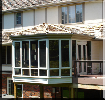 Image of Victorian Conservatory with wood shingled roof to match home, room is built on 2nd story balcony.