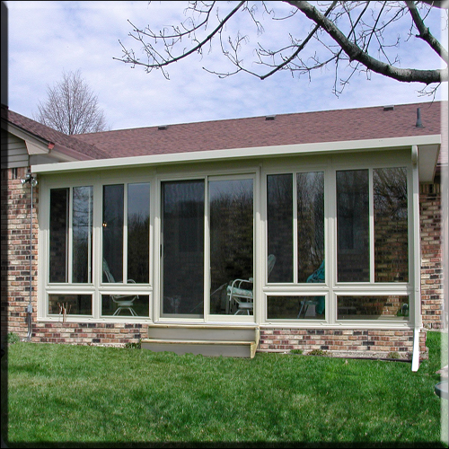 Studio-style composite sunroom w/ brick foundation and deck/patio